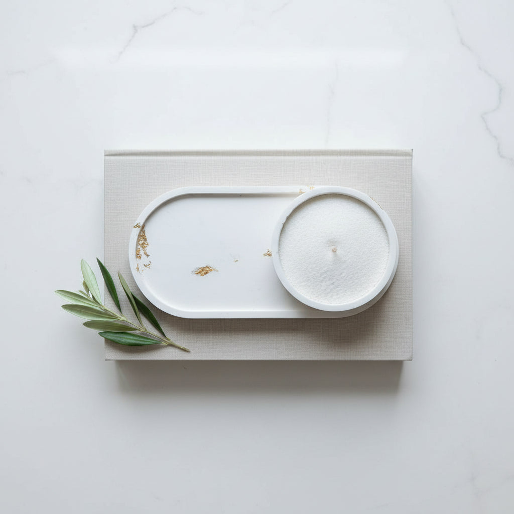 White oval tray with a candlesand bowl laying on a book